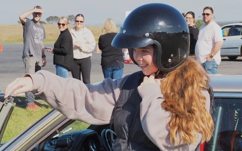 Happy young lady after racing in a WDCC club car