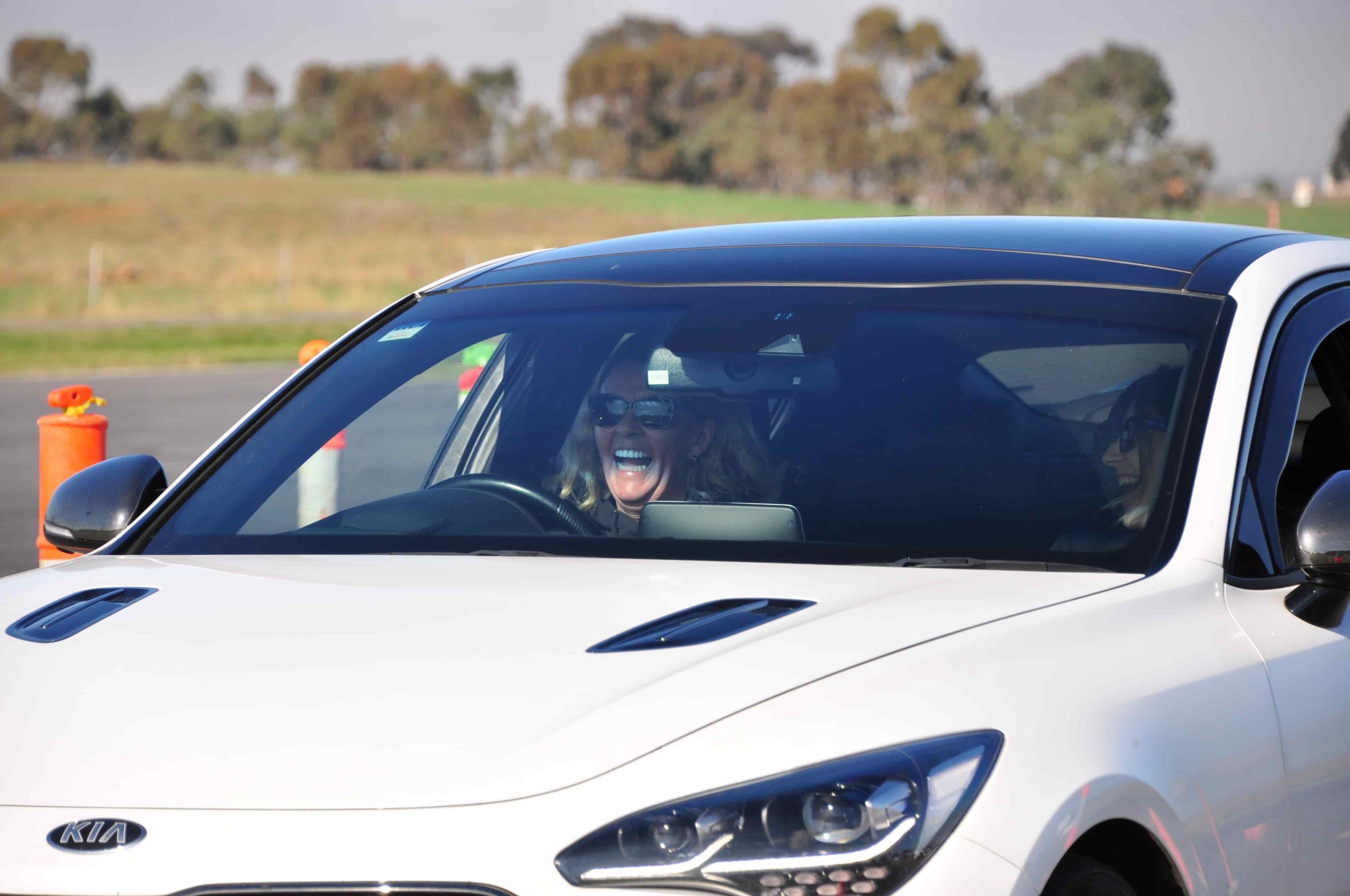 Happy lady smiling and having so much fun racing her car on the skid pan